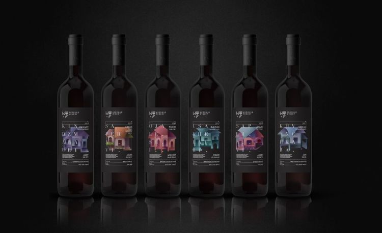 Six black wine bottles with colorful labels on moody dark background