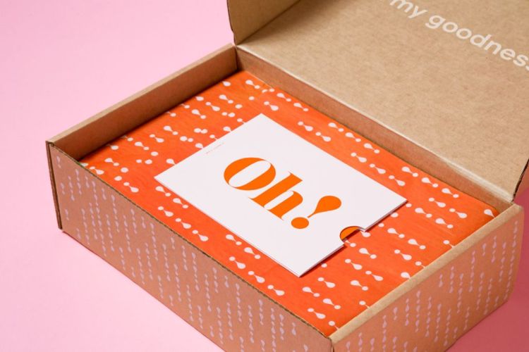 Opened box with orange business card that says "Oh!" on the top